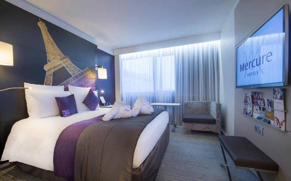 a bedroom with a large bed and a large window at Mercure Paris Centre Tour Eiffel in Paris