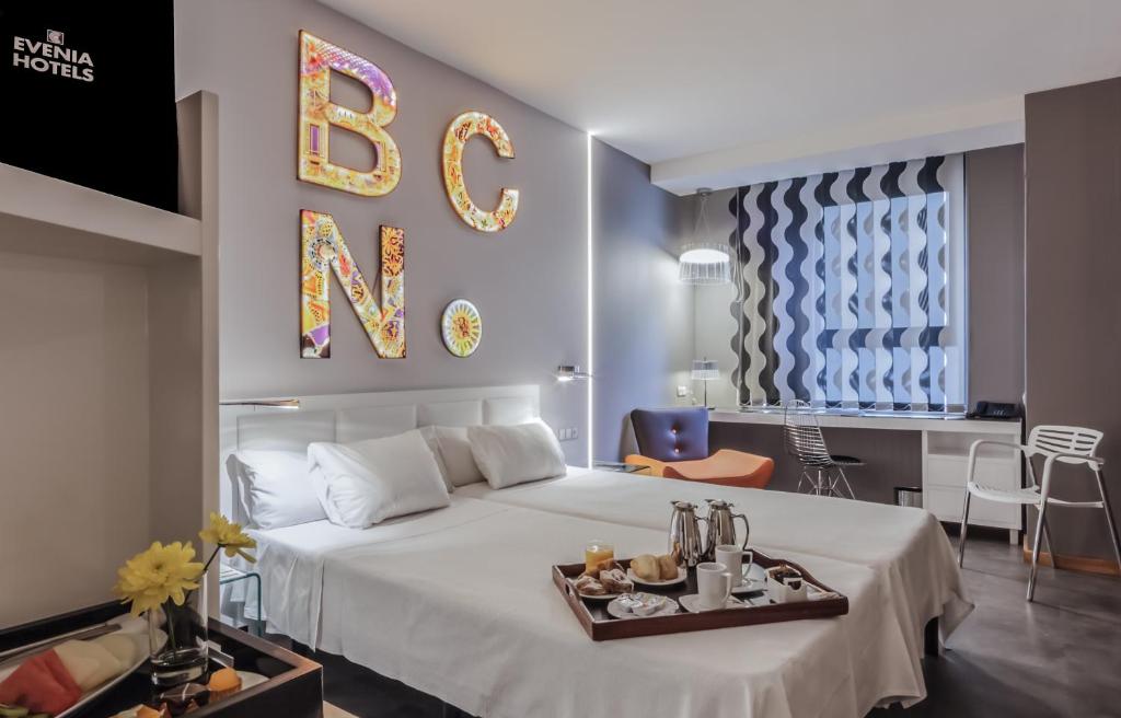 a bedroom with a bed with a tray of food on it at Evenia Rossello in Barcelona