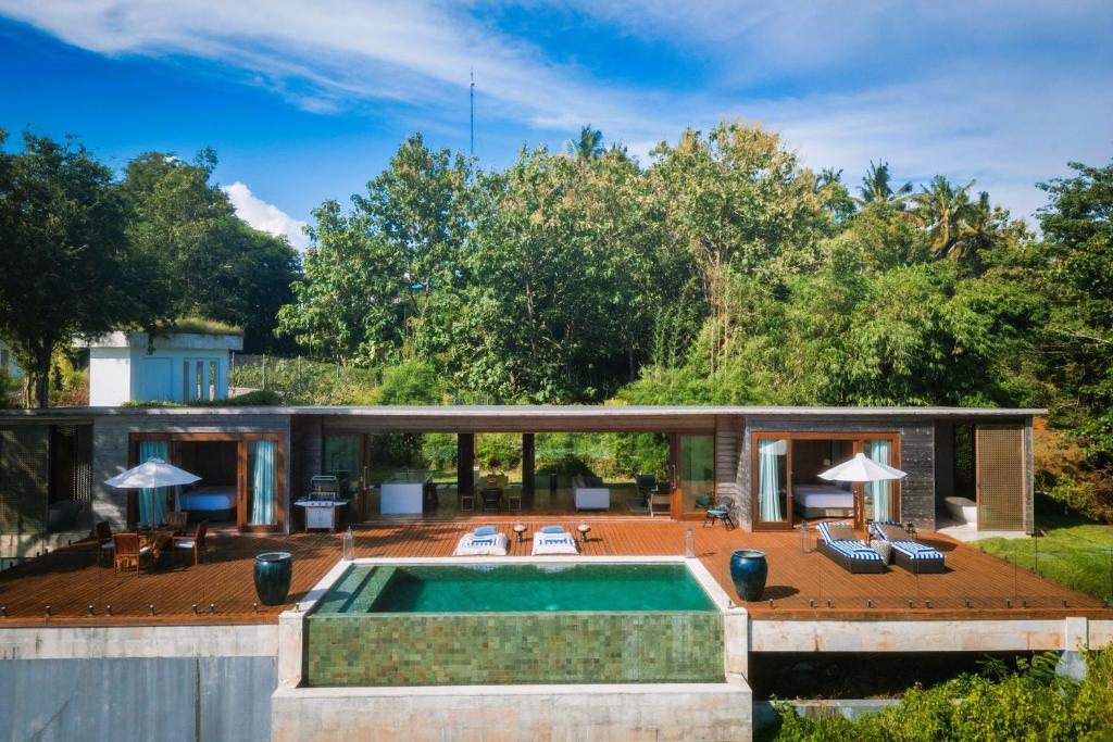 a house with a swimming pool and a patio at Selong Selo Resort and Residences in Selong Belanak