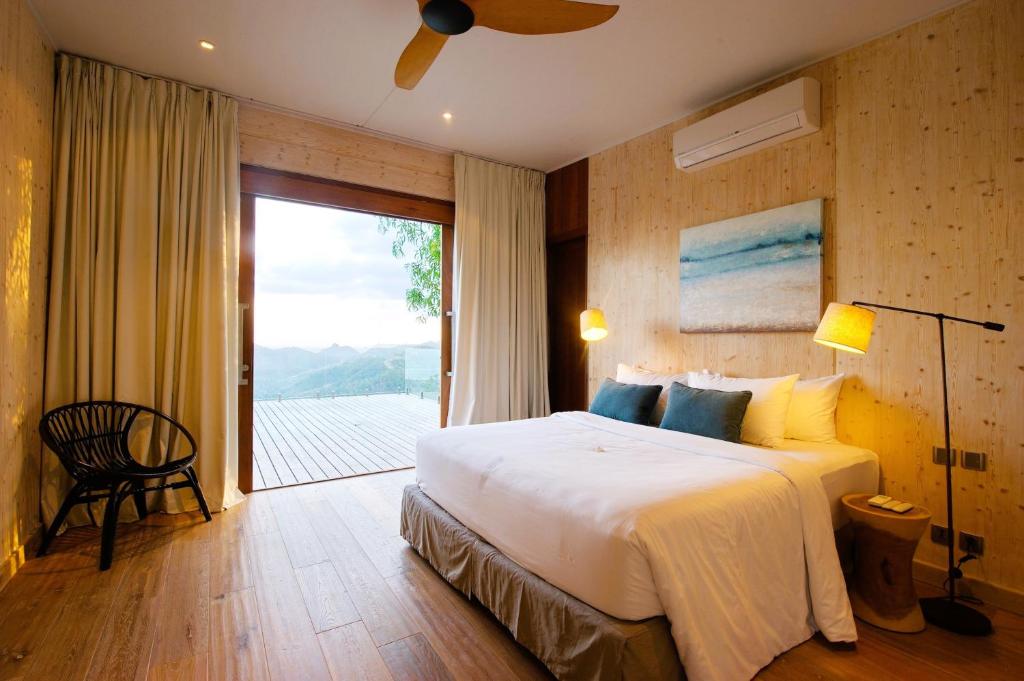 a bedroom with a large bed and a balcony at Selong Selo Resort and Residences in Selong Belanak