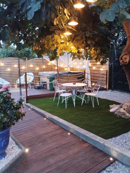 un patio avec une table et des chaises sous un arbre dans l'établissement Détente sous le figuier, à La Garde