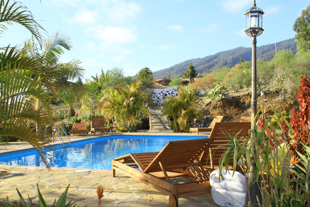 a pool with two lounge chairs and a light pole at Casa Rural Los Abuelos in Tijarafe
