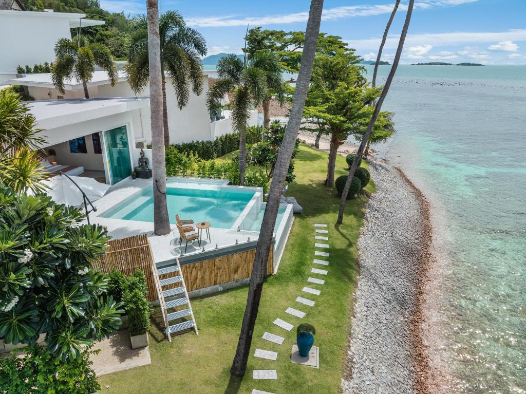 een luchtzicht op een huis met een zwembad en de oceaan bij Beachfront Secret Tides Villa Luna in Koh Samui 