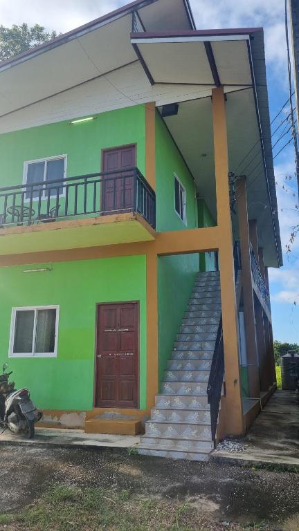 un edificio verde con escaleras delante en Lanta Ahad Apartments, en Ko Lanta