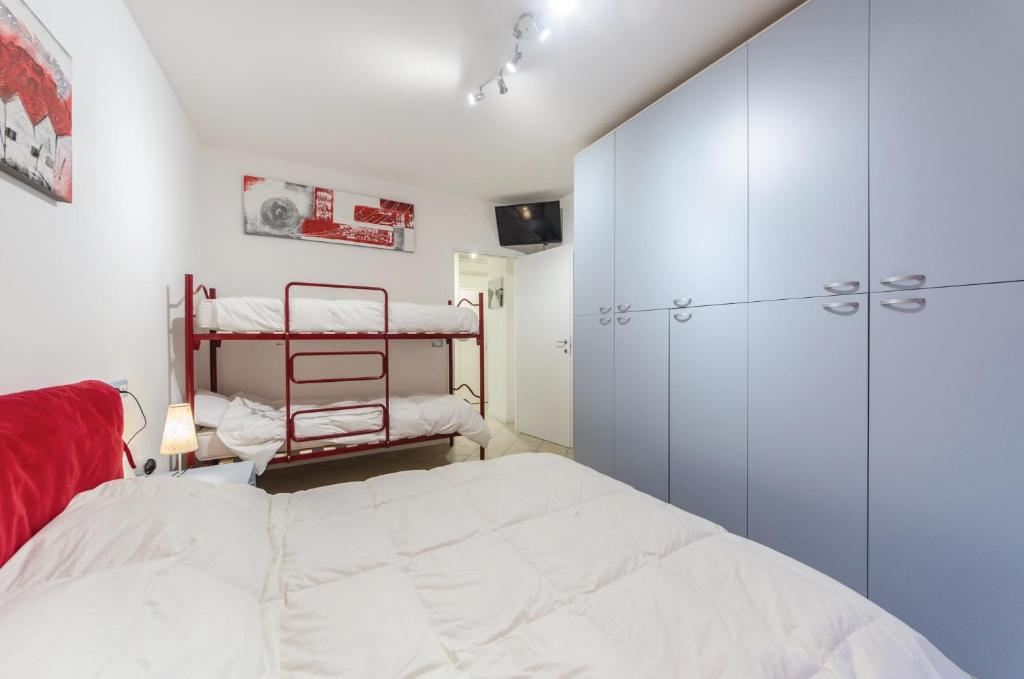 sypialnia z dużym białym łóżkiem i szafą w obiekcie Residence Elisa Piano Terra con Giardino e Posto Spiaggia Incluso w Caorle