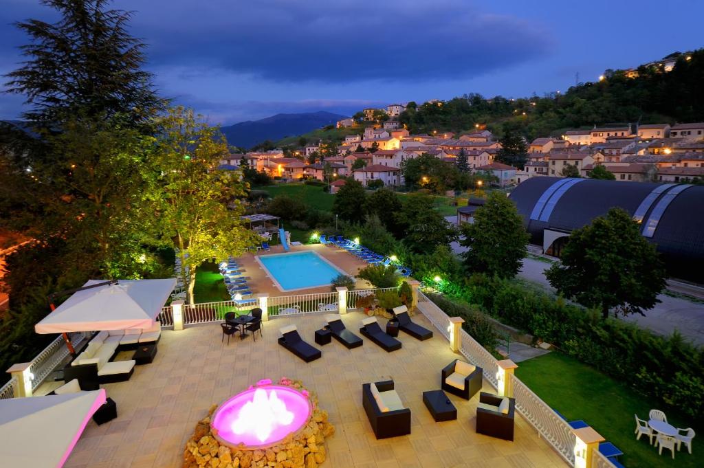 vistas panorámicas a un patio con piscina y sillas en Hotel Benessere Villa Fiorita, en Colfiorito