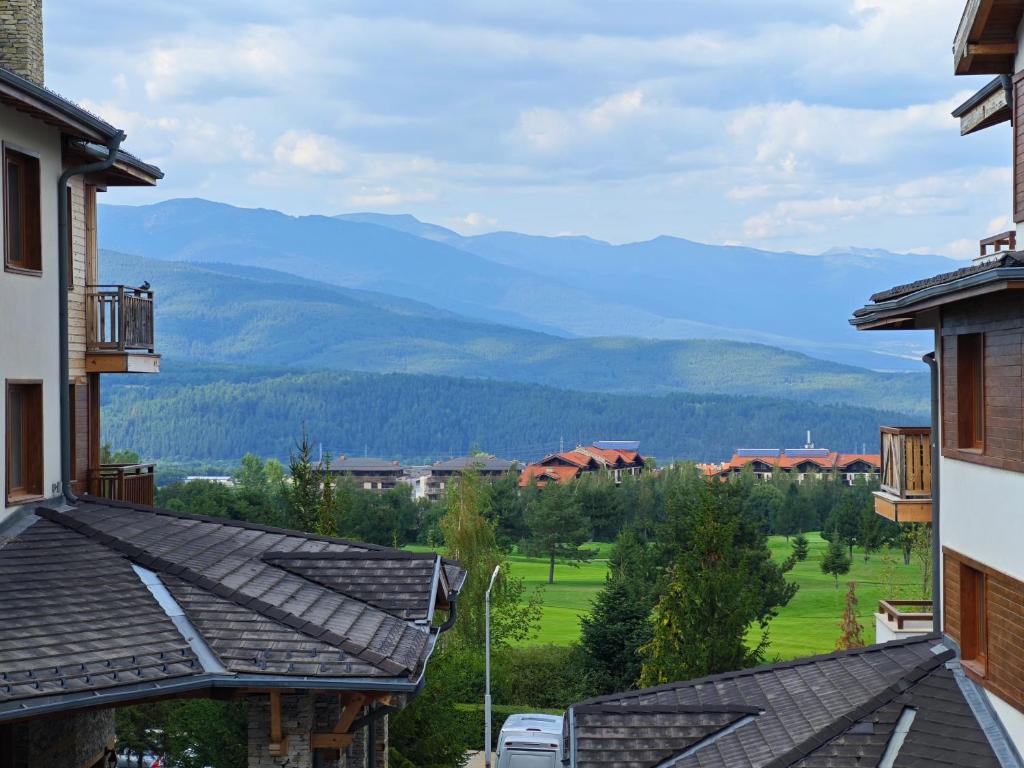 a view of the mountains from the roofs of buildings at Bansko Pirin Golf & Country Club Blue Mountains View in Razlog