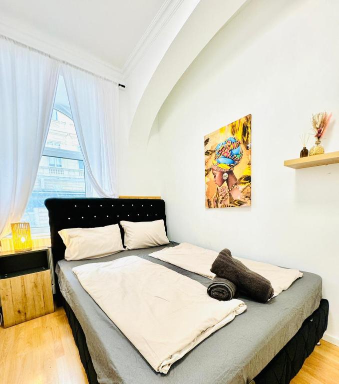 ウィーンにあるComfy Rooms in a Shared Apt, 8Min to Rathausplatzの壁に絵画が描かれたベッドルームのベッド1台