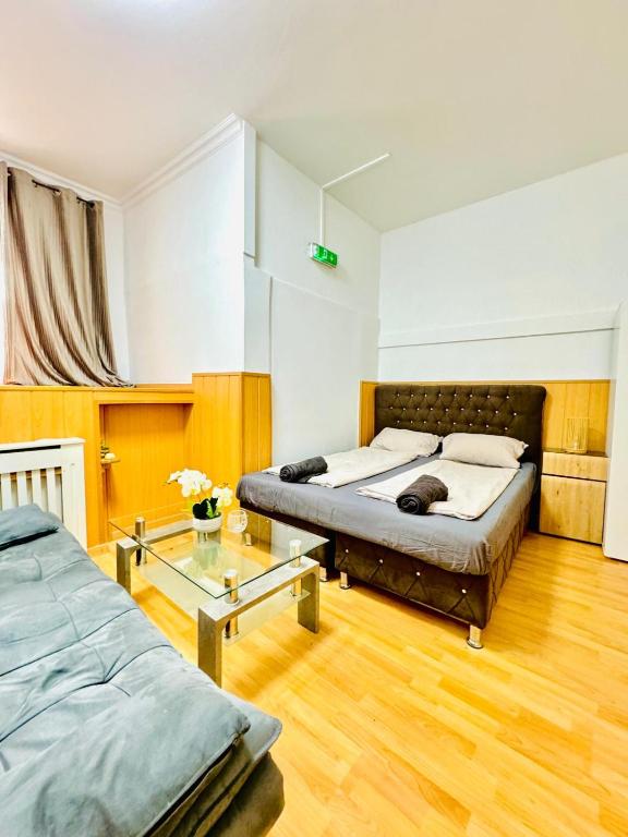 een slaapkamer met 2 bedden en een glazen tafel bij Comfy Rooms in a Shared Apt, 8Min to Rathausplatz in Wenen
