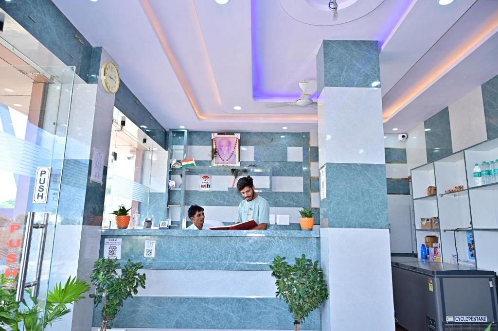 two people standing at a counter in a dental office at Hotel Radha Palace & Restaurant in Khātu