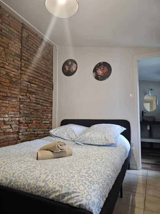 une chambre avec un lit avec un chapeau dessus dans l'établissement L'Aristide proche gare parking facile, à Montauban