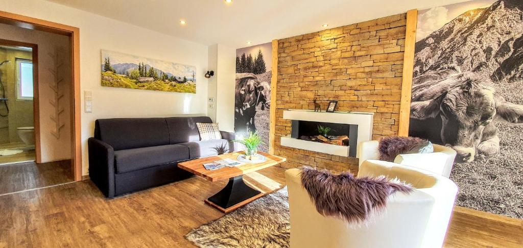 プフロンテンにあるFerienwohnungen Wolf - Wohnung" Kienberg" mit Bergblickのソファと暖炉のあるリビングルーム