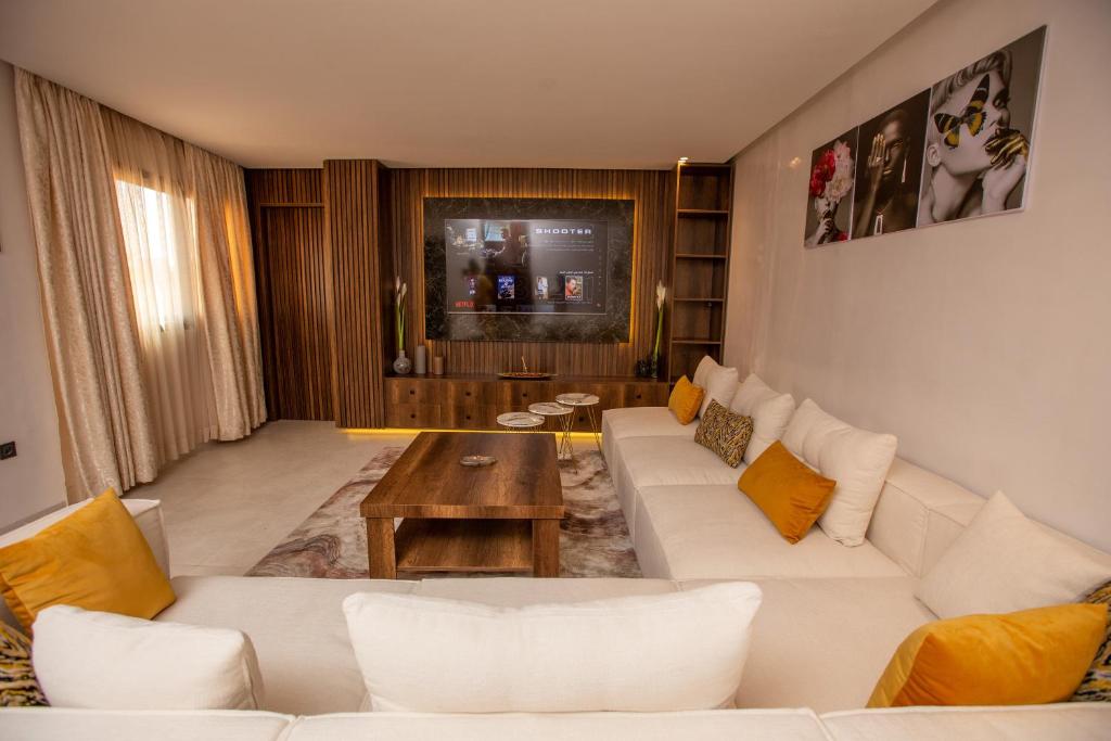 a living room with a white couch and a table at Élégance et Prestige à Gueliz Appartement 3 chambres in Marrakech