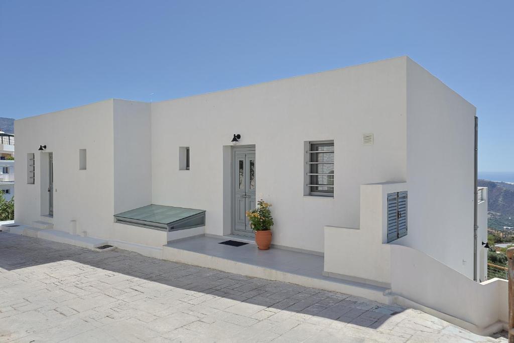 a white building with a bench on the side of it at South Akro in Míthoi