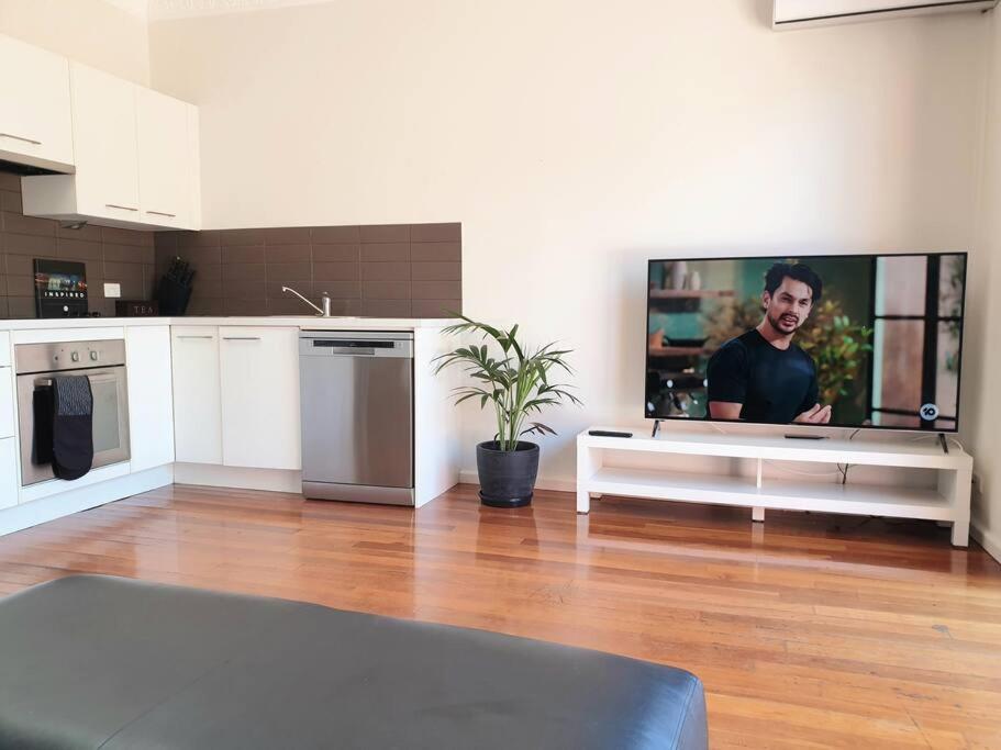 a living room with a flat screen tv on the wall at Port Melbourne Victorian Cottage in Melbourne