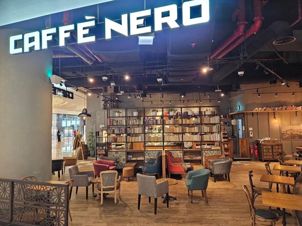 a coffee shop with chairs and a sign on the ceiling at C-Suite Views at Al Reem and Al Maryah Island in Abu Dhabi