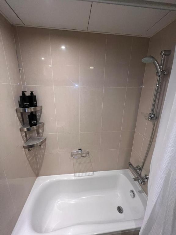a white bath tub in a bathroom with a shower at C-Suite Views at Al Reem and Al Maryah Island in Abu Dhabi