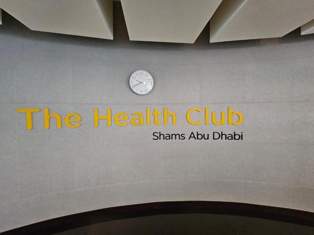 a health club sign on a wall with a clock at C-Suite Views at Al Reem and Al Maryah Island in Abu Dhabi