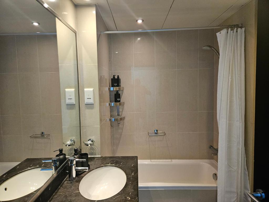 a bathroom with a sink and a bath tub at C-Suite Views at Al Reem and Al Maryah Island in Abu Dhabi