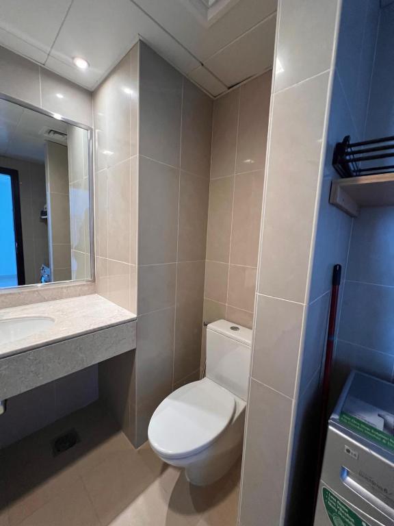 a bathroom with a toilet and a sink and a mirror at C-Suite Views at Al Reem and Al Maryah Island in Abu Dhabi