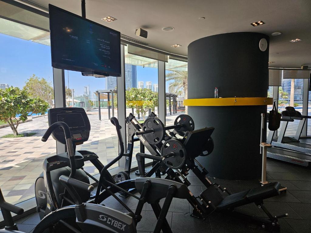 a gym with several cardio bikes and a television at C-Suite Views at Al Reem and Al Maryah Island in Abu Dhabi
