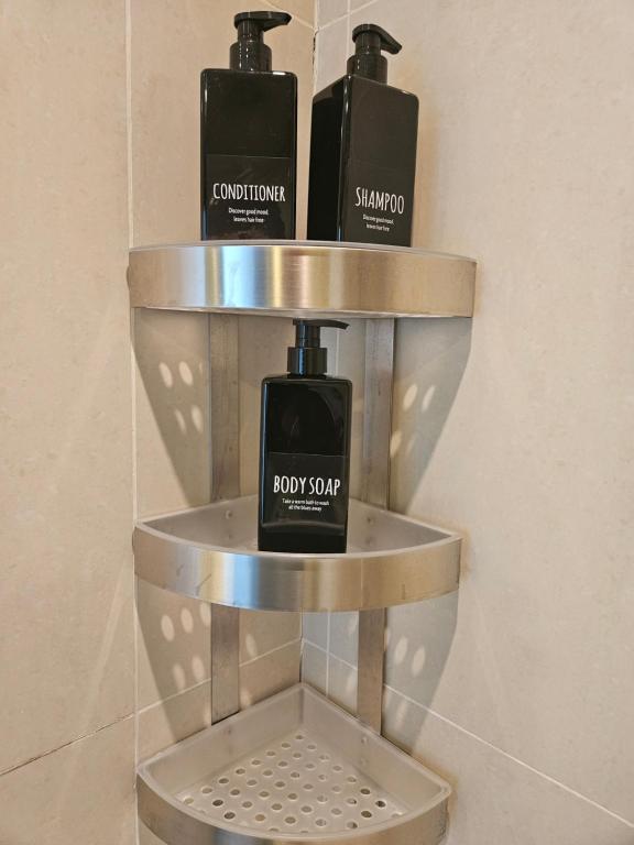 a shelf with two bottles of soap in a bathroom at C-Suite Views at Al Reem and Al Maryah Island in Abu Dhabi