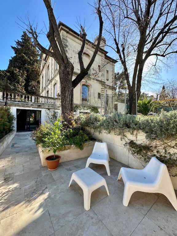 trois bancs blancs assis devant un bâtiment dans l'établissement T2 Centre-Ville avec Grand Espace Vert - 15mn des Plages, à Montpellier