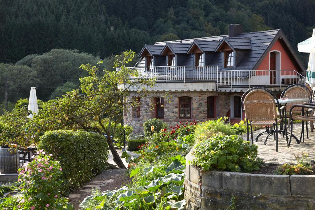 a house with solar panels on top of a garden at Hotel Haus Kylltal in Zendscheid