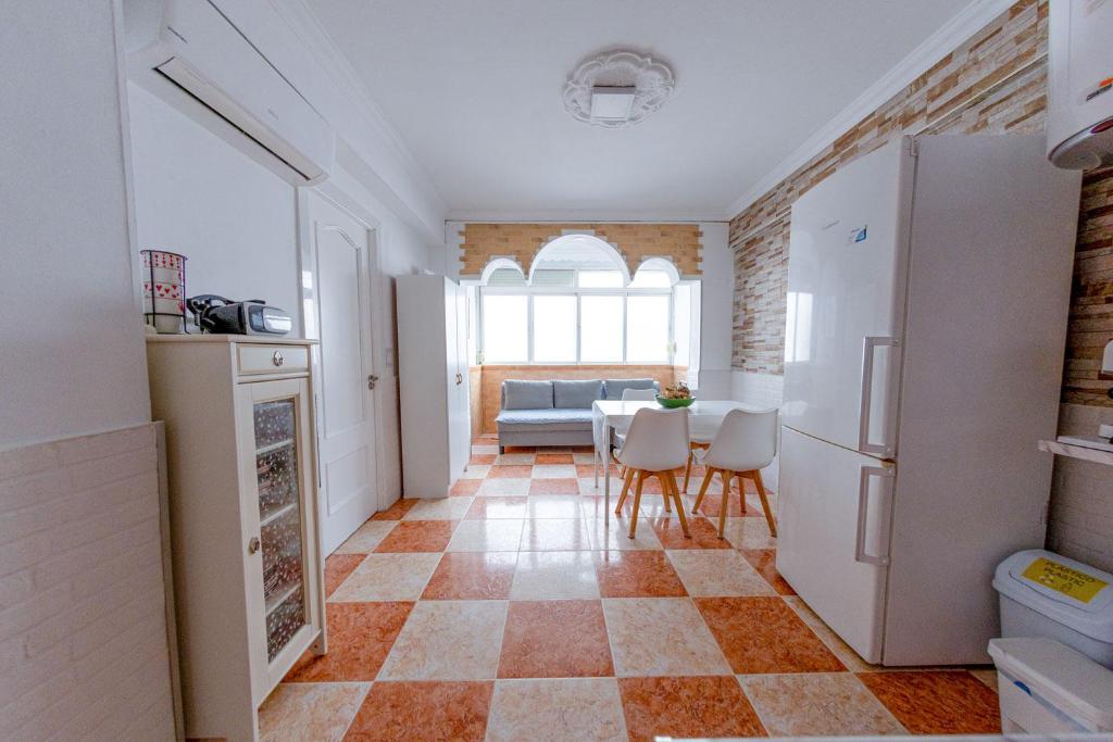 a kitchen and dining room with a table and chairs at Habitación a 7 mins centro Turístico Torremolinos in Torremolinos