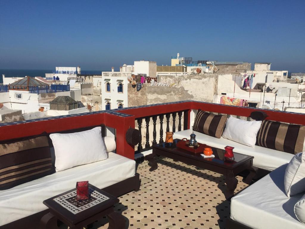a balcony with two couches and a view of a city at Riad Bab Essaouira in Essaouira