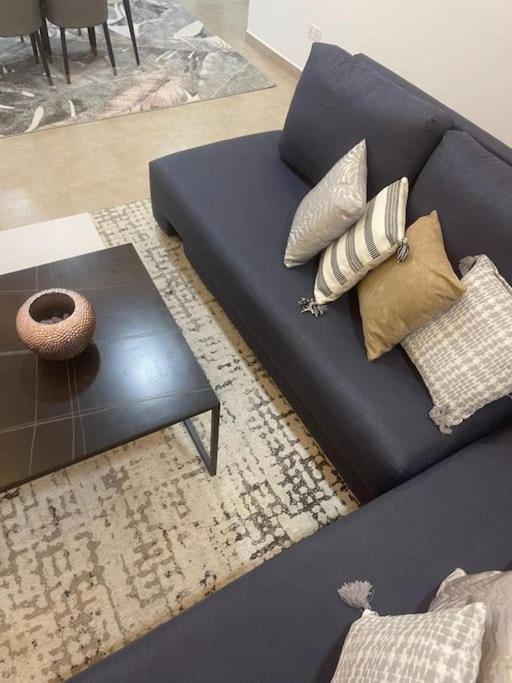 a blue couch with pillows and a table in a living room at Luxury 2 bed 2bath East Legon in Madina
