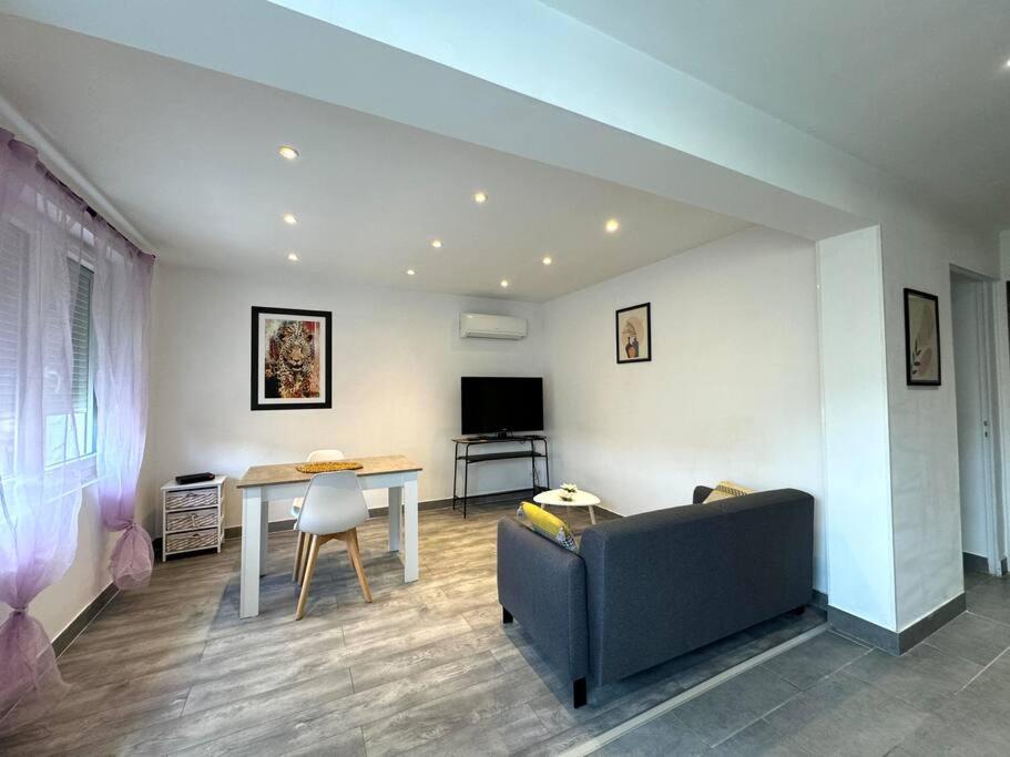 un salon avec un canapé et une table dans l'établissement Maison de village, garage & climatisation, à Les Roches-de-Condrieu