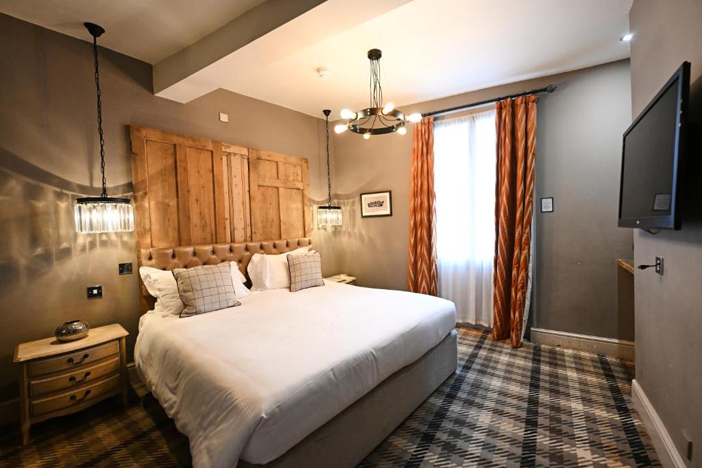 a bedroom with a large bed and a flat screen tv at The King's Head in Beverley