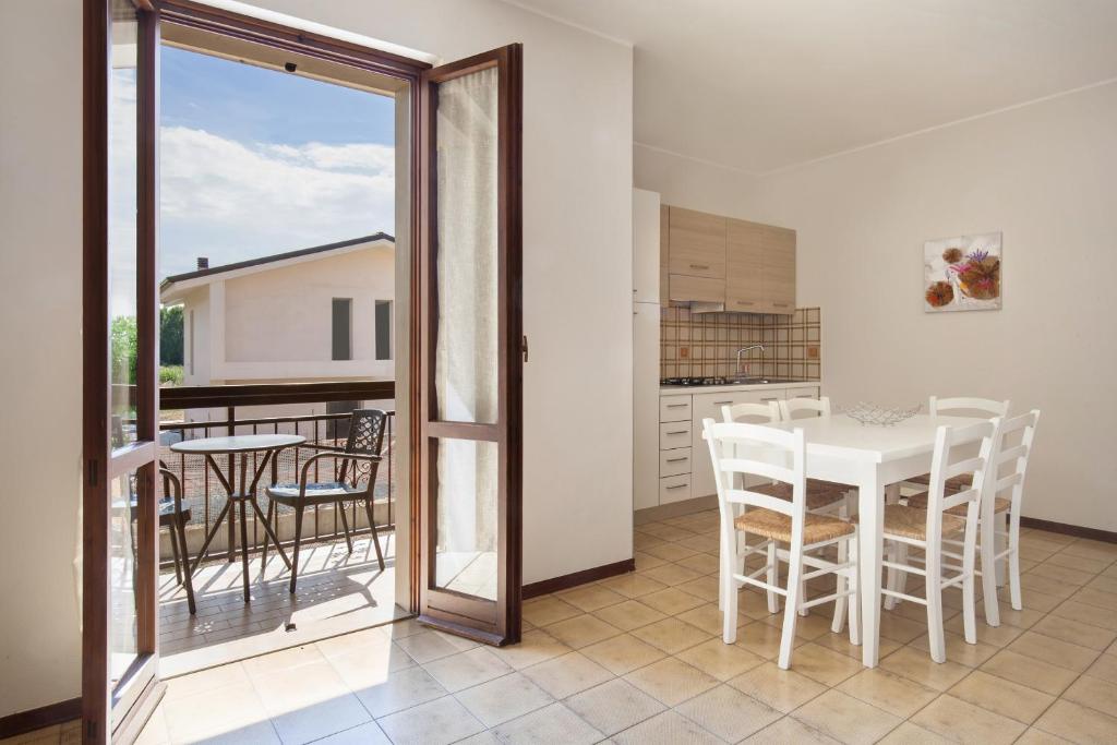 una cucina e una sala da pranzo con tavolo e sedie di Apartment Rosa Cinderella a Lazise