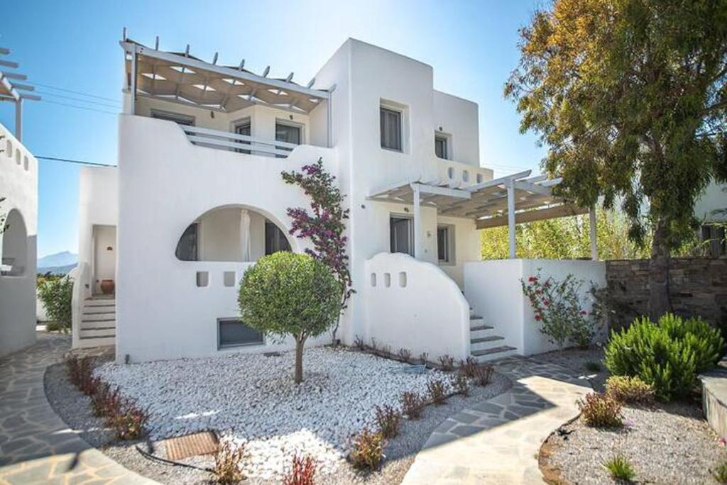 a white house with a tree in front of it at Magganari Home Stelida Naxos in Agios Prokopios