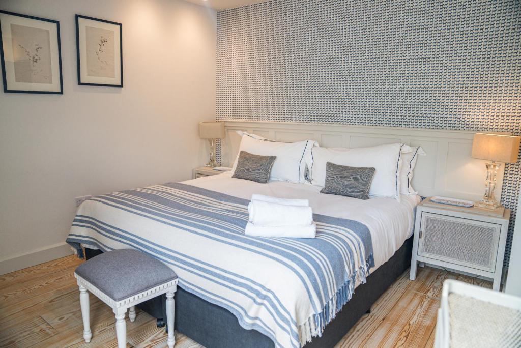 a bedroom with a large bed and a chair at Linhay Cottages 2 in Bathford
