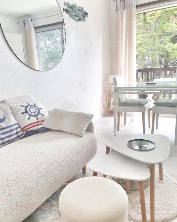 - un salon avec un canapé blanc et un miroir dans l'établissement Studio front de mer, à Merville-Franceville-Plage