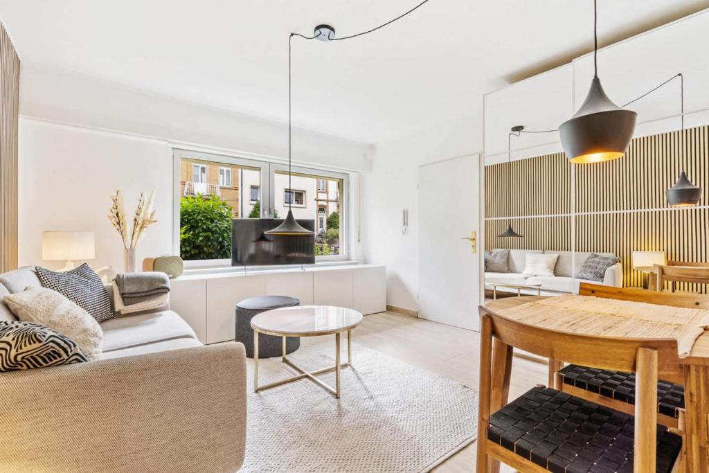 una sala de estar con un sofá y una mesa en Chic Limpertsberg Studio with Free Parking & Wi-Fi, en Luxemburgo