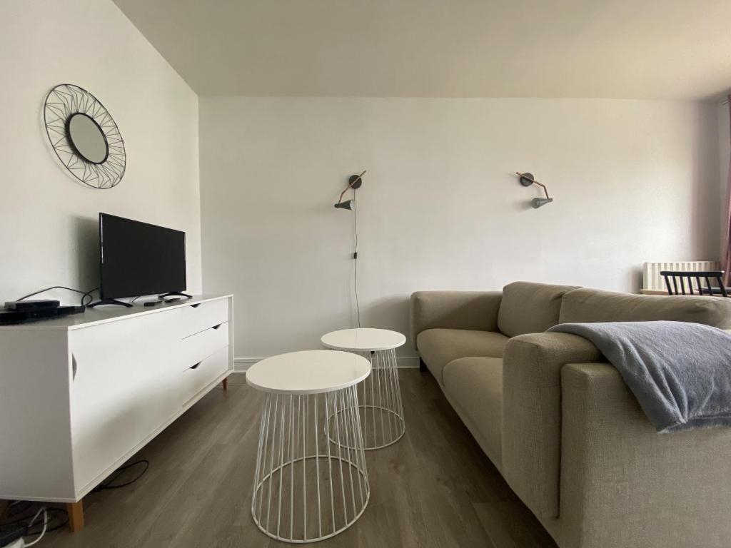 a living room with a couch and two tables at Appartement pour 8 personnes à Mont-Saint-Aignan - 217 in Mont-Saint-Aignan