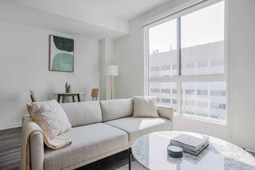 a white living room with a couch and a table at Blueground Long Beach pool gym near bars LAX-1260 in Los Angeles