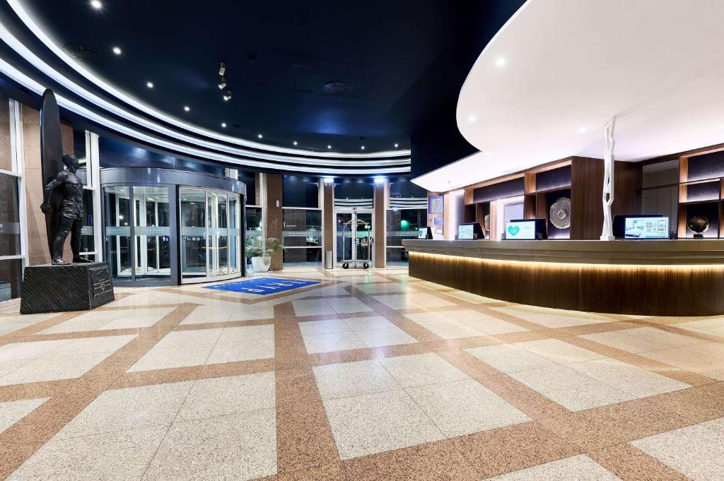 a lobby with a statue in the middle of a building at TRYP by Wyndham Lisboa Caparica Mar in Costa da Caparica