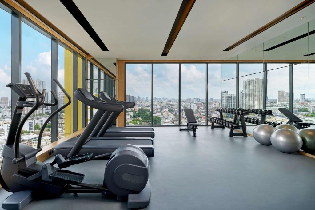 A window-lined gym with treadmills, cross-trainers, dumbbells and exercise balls.