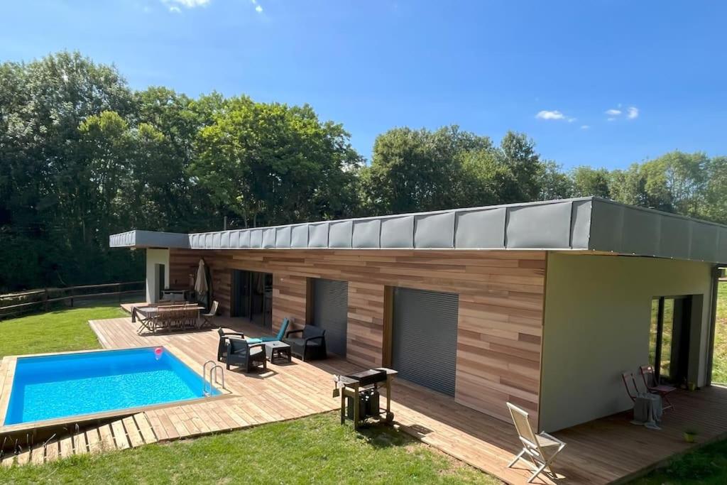 une maison avec une piscine dans l'arrière-cour dans l'établissement Un havre de paix au pied du Golf, à Saint-Martin-du-Vieux-Bellême