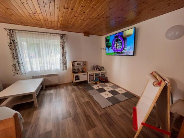 salon ze stołem i telewizorem na ścianie w obiekcie Chalupa U Smrku w mieście Horní Polubný