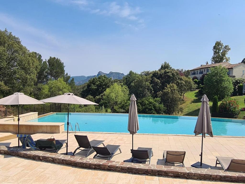 - une piscine avec des parasols et des chaises longues dans l'établissement Apartment in La Motte near Golf Course, à La Motte