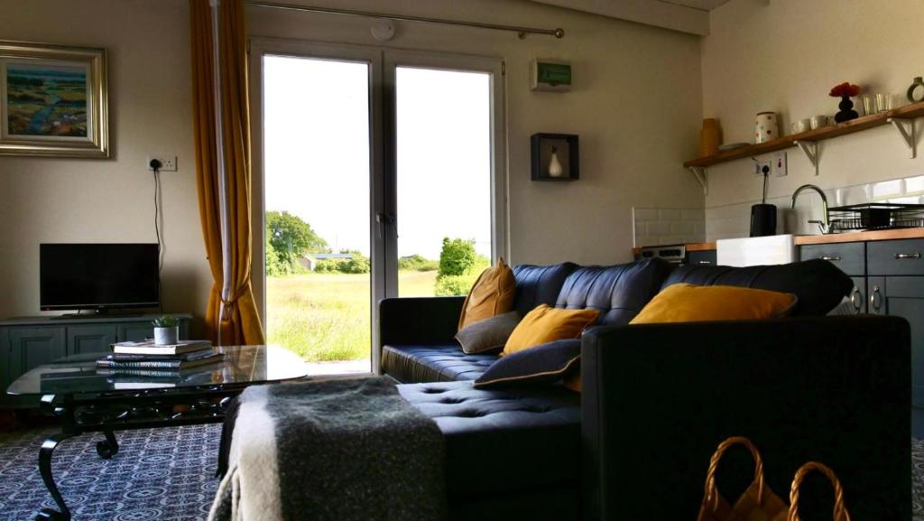 un soggiorno con un divano blu e una finestra di The Tin Shed a Tara