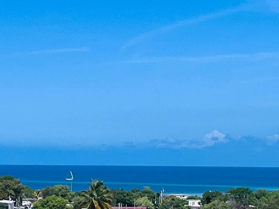 a clear blue sky over the ocean with palm trees at Ubicación genial a 3 minutos de combate Beach in El Combate
