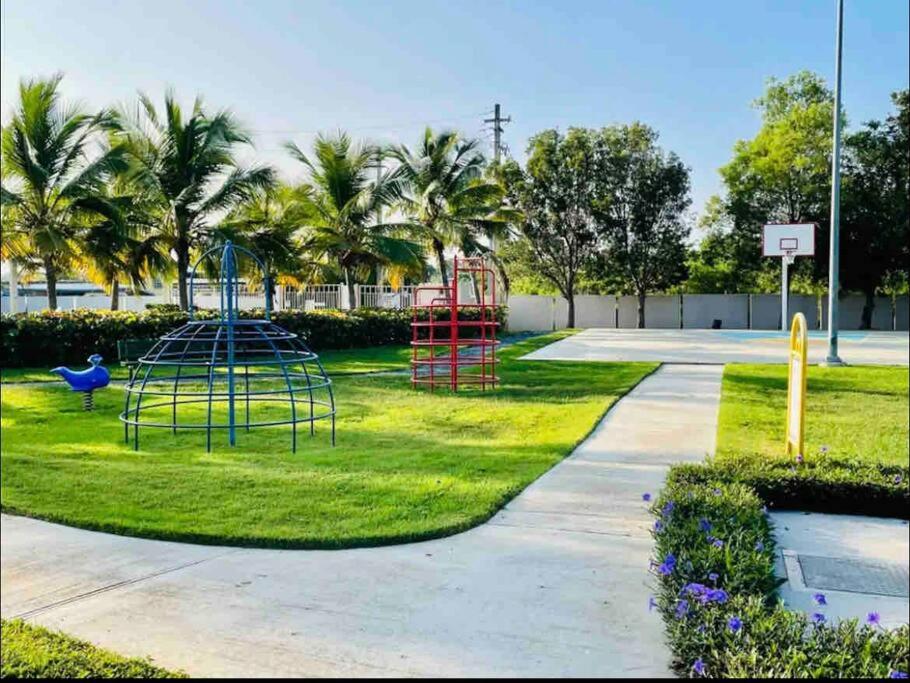 a playground in a park with palm trees at Ubicación genial a 3 minutos de combate Beach in El Combate
