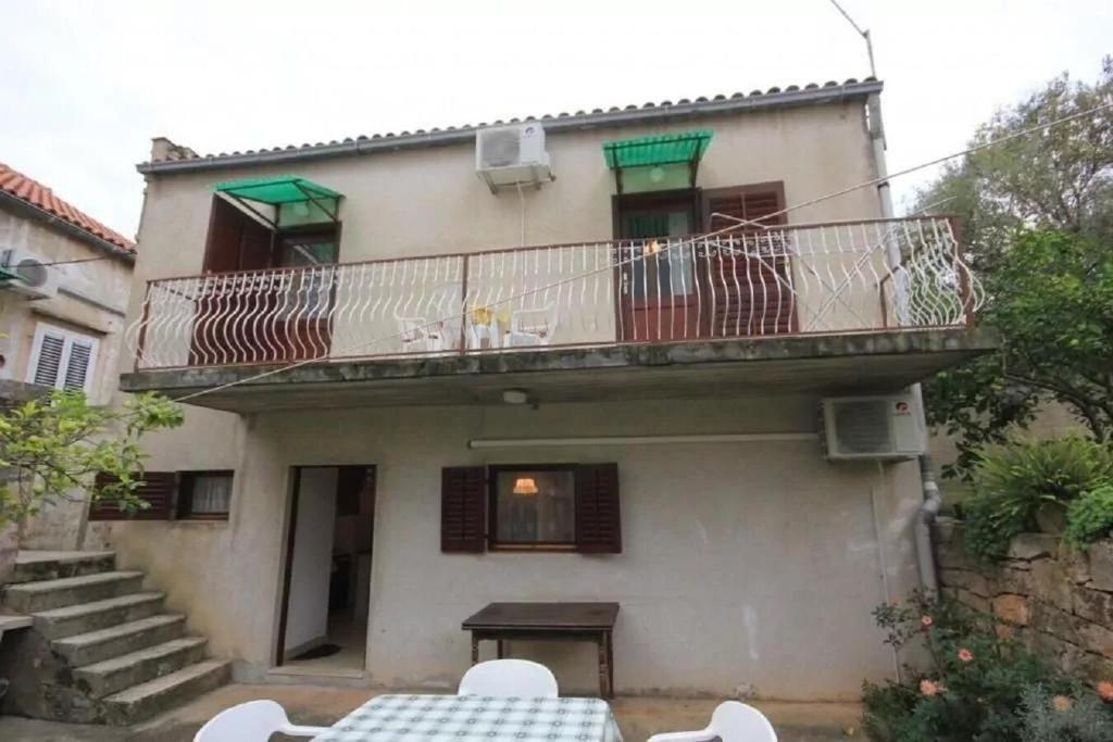 an apartment building with a balcony and a table at Apartment Tenara in Vis