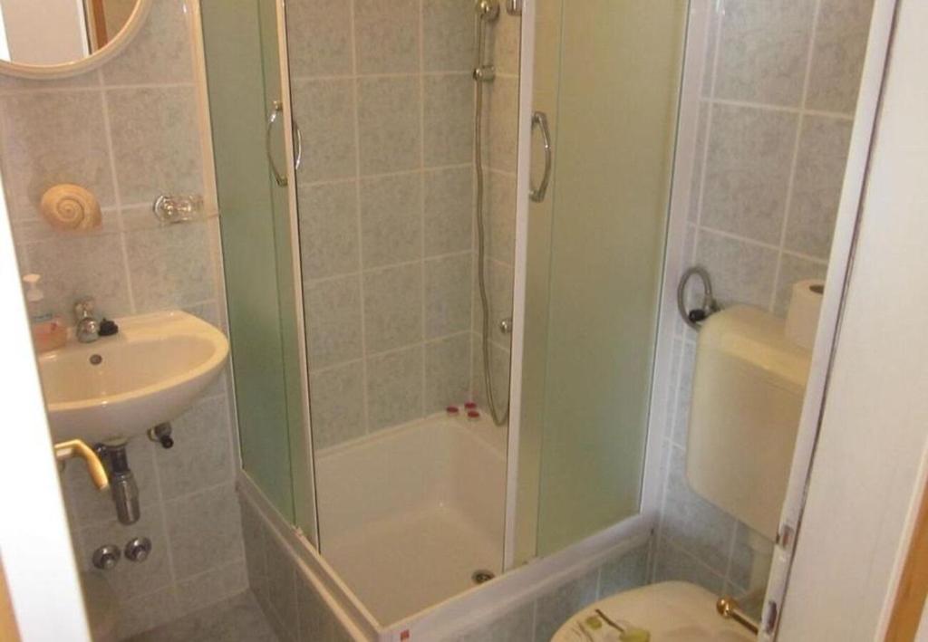 łazienka z prysznicem, toaletą i umywalką w obiekcie Apartments and Room Dar w Hvarze
